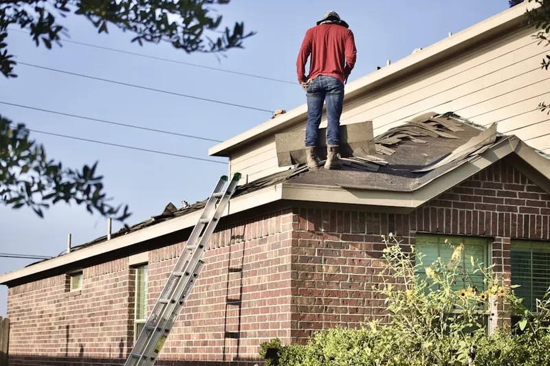 Professional roofer working on a residential roof in Menomonee Falls